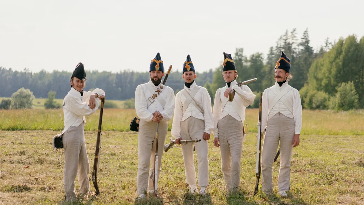 Group of men in Napoleonic uniforms posing outdoors in a historical reenactment.